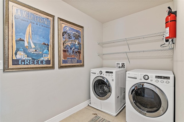 laundry area with laundry area, light tile patterned flooring, baseboards, and independent washer and dryer