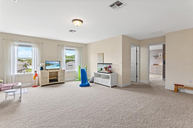 recreation room with visible vents, carpet floors, and plenty of natural light