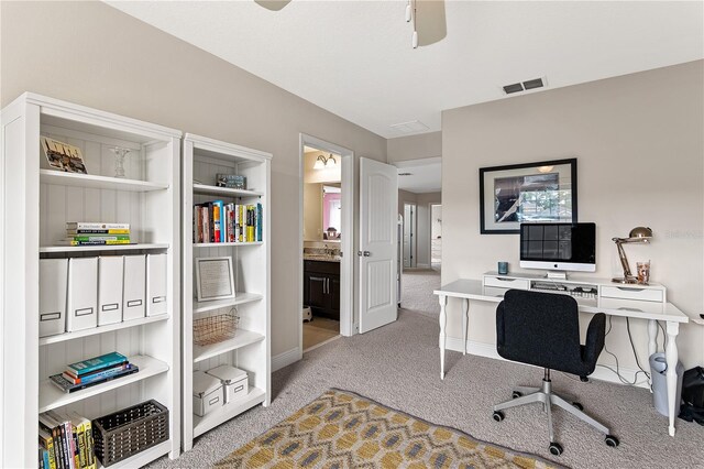office area featuring visible vents, light colored carpet, and ceiling fan