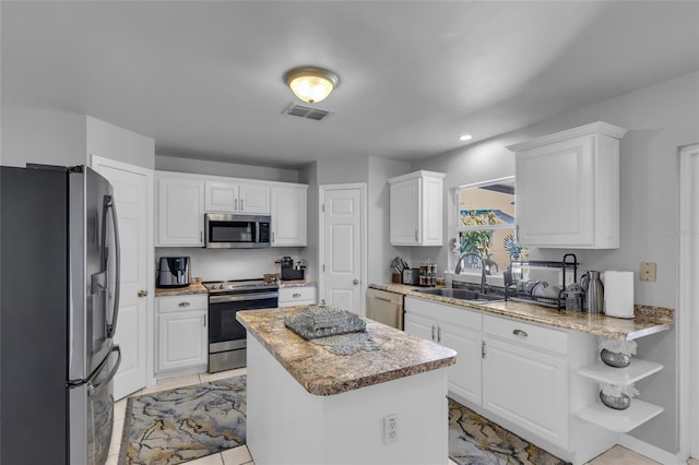 122 Carmel Bay Dr, Sanford, FL 32771 - kitchen with visible vents, a kitchen island, appliances with stainless steel finishes, white cabinets, and a sink