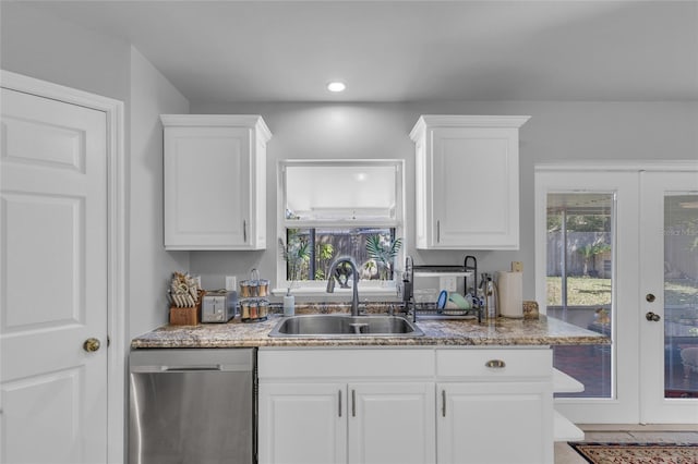 122 Carmel Bay Dr, Sanford, FL 32771 - kitchen with light stone counters, white cabinetry, a sink, french doors, and stainless steel dishwasher