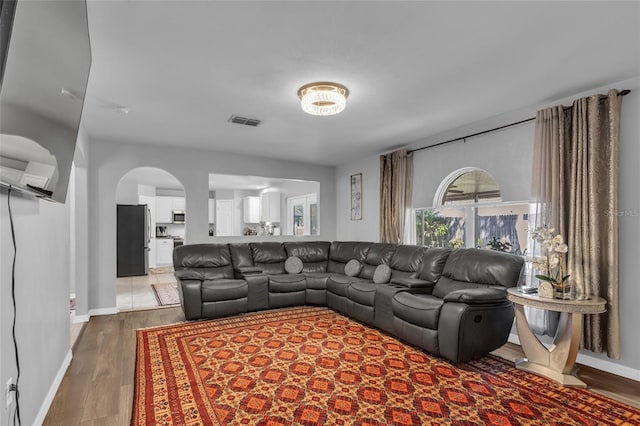 122 Carmel Bay Dr, Sanford, FL 32771 - living area featuring wood finished floors, arched walkways, visible vents, and baseboards