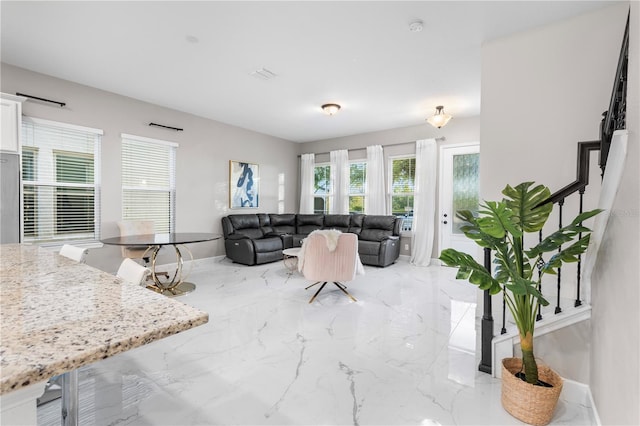 living room featuring marble finish floor and stairs