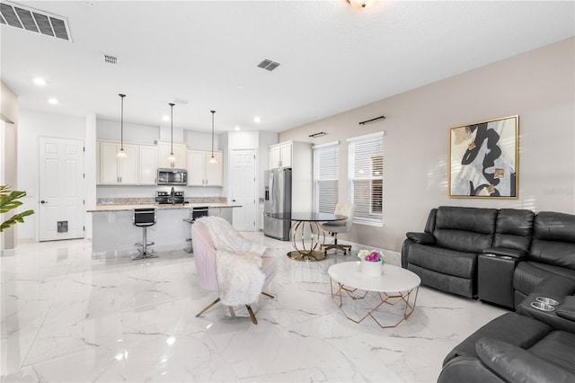 living area featuring visible vents and marble finish floor
