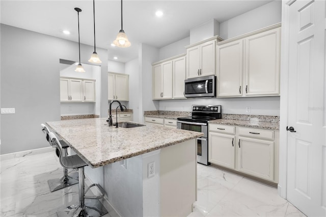 kitchen featuring marble finish floor, light stone countertops, stainless steel appliances, and a sink