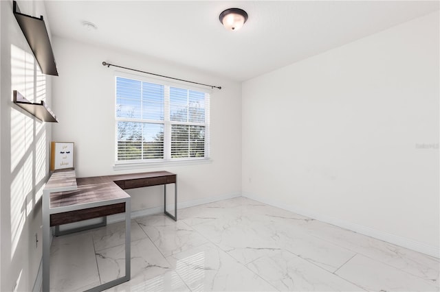 home office featuring baseboards and marble finish floor