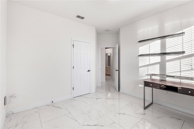 interior space featuring visible vents, marble finish floor, and baseboards