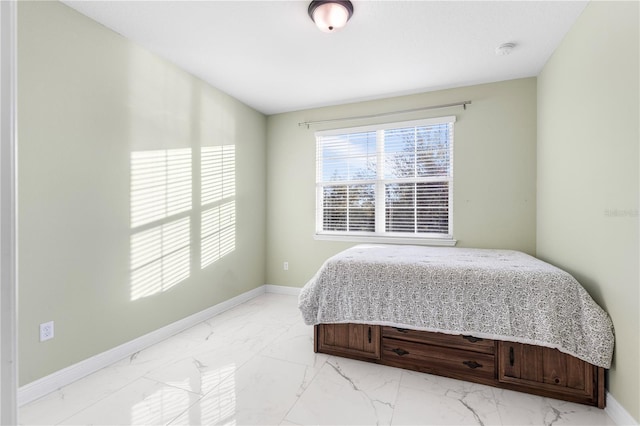 bedroom featuring marble finish floor and baseboards
