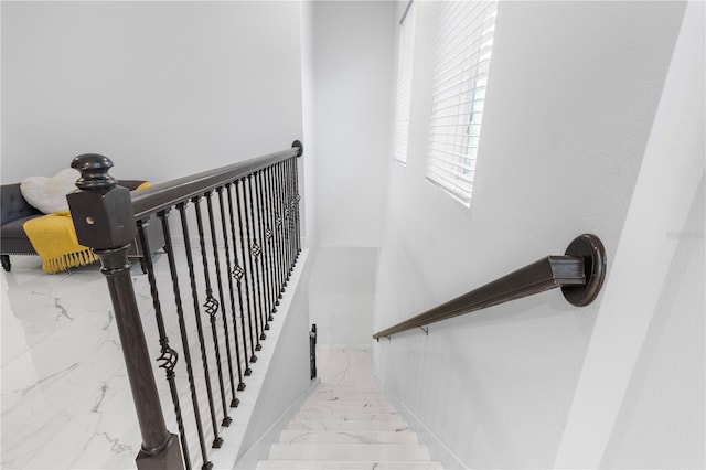staircase with baseboards and marble finish floor