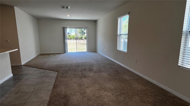2597 Shamrock St, Tavares, FL 32778 - carpeted empty room featuring tile patterned floors, baseboards, and visible vents