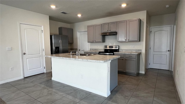 2597 Shamrock St, Tavares, FL 32778 - kitchen featuring visible vents, gray cabinets, a sink, under cabinet range hood, and appliances with stainless steel finishes