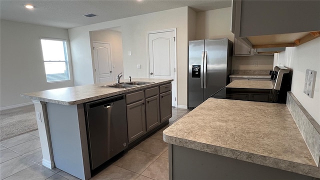 2597 Shamrock St, Tavares, FL 32778 - kitchen with visible vents, an island with sink, appliances with stainless steel finishes, light tile patterned flooring, and a sink