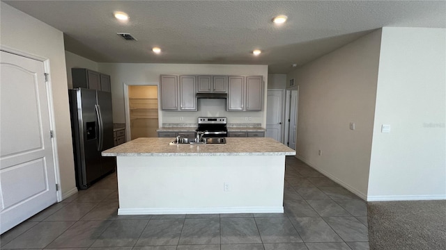 2597 Shamrock St, Tavares, FL 32778 - kitchen with visible vents, an island with sink, gray cabinets, stainless steel appliances, and light countertops