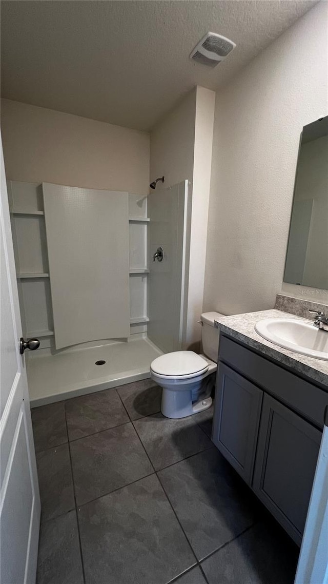 2597 Shamrock St, Tavares, FL 32778 - full bath with vanity, visible vents, a walk in shower, a textured ceiling, and toilet