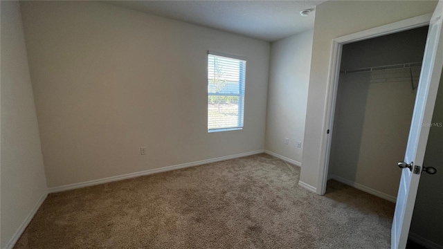 2597 Shamrock St, Tavares, FL 32778 - unfurnished bedroom with a closet, baseboards, and carpet flooring