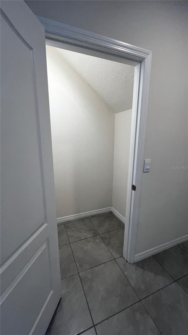 2597 Shamrock St, Tavares, FL 32778 - corridor with tile patterned flooring, a textured ceiling, and baseboards