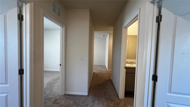 2597 Shamrock St, Tavares, FL 32778 - hallway featuring carpet flooring, baseboards, visible vents, and a sink