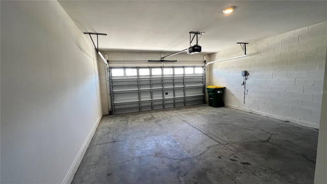 2597 Shamrock St, Tavares, FL 32778 - garage with concrete block wall, a garage door opener, and baseboards