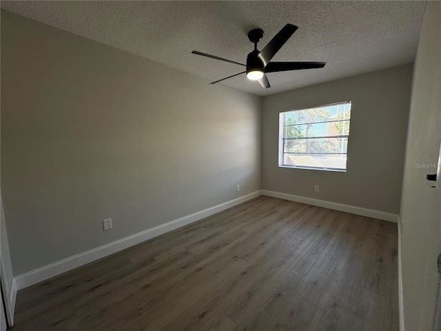 unfurnished room featuring ceiling fan, baseboards, a textured ceiling, and wood finished floors