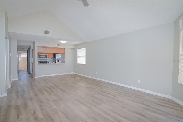 unfurnished living room featuring baseboards, visible vents, light wood finished floors, and a sink