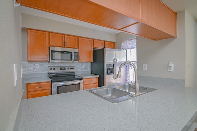 kitchen featuring backsplash, stainless steel appliances, light countertops, and a sink
