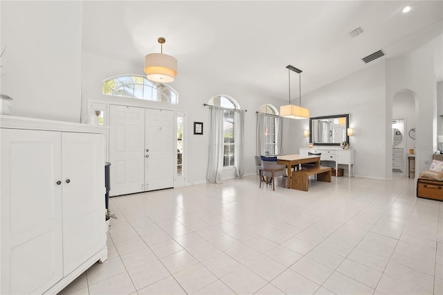 551 Wheatstone Pl, Orlando, FL 32835 - foyer entrance with high vaulted ceiling, arched walkways, visible vents, light tile patterned flooring, and baseboards