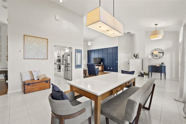 551 Wheatstone Pl, Orlando, FL 32835 - dining area featuring light tile patterned floors, ceiling fan, a towering ceiling, and baseboards
