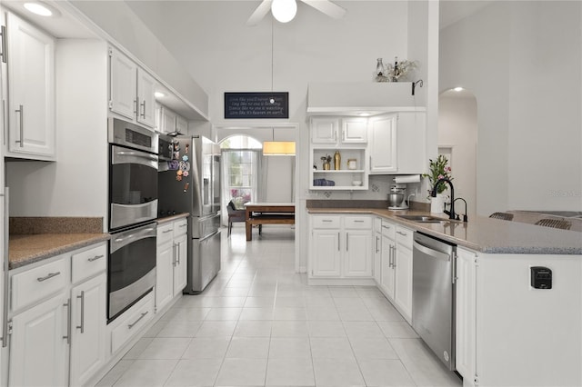 551 Wheatstone Pl, Orlando, FL 32835 - kitchen with a peninsula, a ceiling fan, white cabinets, a sink, and stainless steel appliances