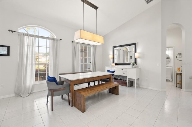 551 Wheatstone Pl, Orlando, FL 32835 - dining area with light tile patterned flooring, arched walkways, high vaulted ceiling, and baseboards
