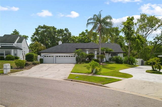 551 Wheatstone Pl, Orlando, FL 32835 - view of front of property featuring concrete driveway, a front yard, a garage, and a chimney