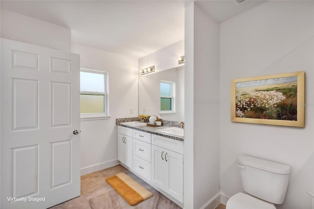 16171 SW 44th Cir, Ocala, FL 34473 - bathroom featuring double vanity, baseboards, and toilet