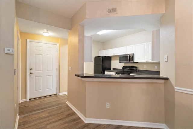 kitchen featuring dark countertops, black appliances, baseboards, wood finished floors, and white cabinetry