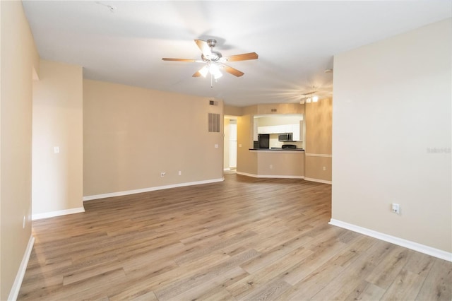 unfurnished living room with light wood-type flooring, baseboards, and ceiling fan