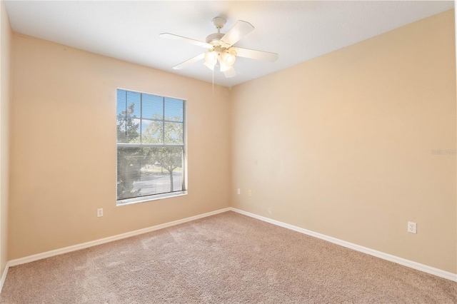 empty room featuring baseboards, carpet floors, and ceiling fan