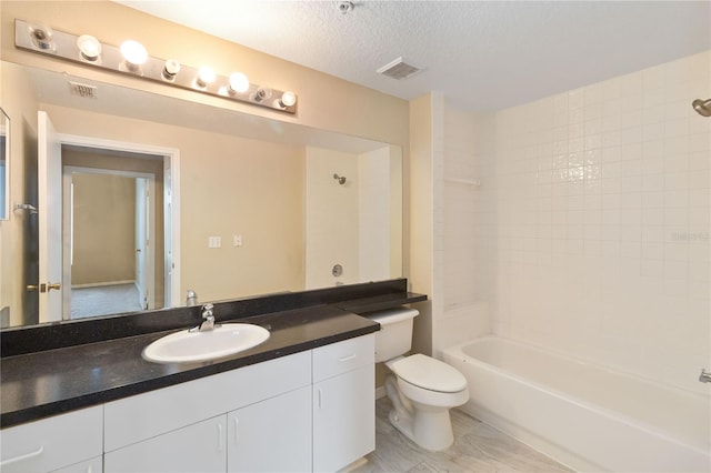 bathroom featuring vanity, toilet, visible vents, and a textured ceiling