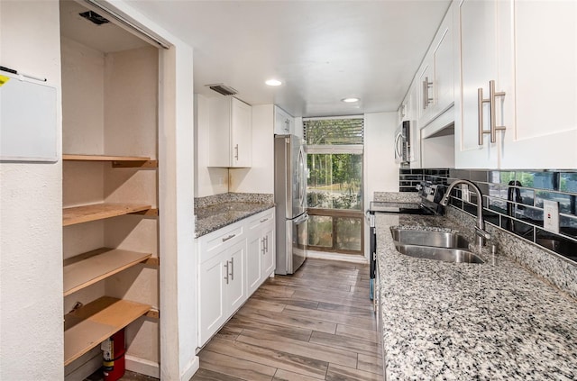 40 Moree Loop Unit 11, Winter Springs, FL 32708 - kitchen featuring stainless steel appliances, a sink, white cabinets, recessed lighting, and light wood finished floors