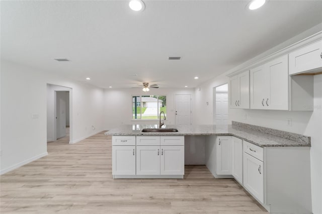 23741 SW Blueberry Ln, Dunnellon, FL 34431 - kitchen with a peninsula, a ceiling fan, white cabinets, light wood finished floors, and recessed lighting