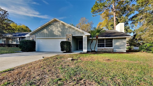 single story home with a front lawn, a chimney, concrete driveway, and an attached garage