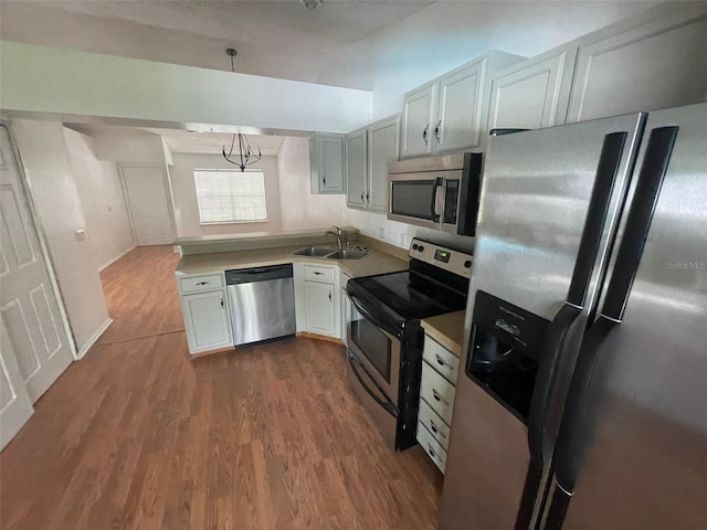 5417 Lake Margaret Dr Unit 39, Orlando, FL 32812 - kitchen with dark wood finished floors, light countertops, a peninsula, stainless steel appliances, and a sink