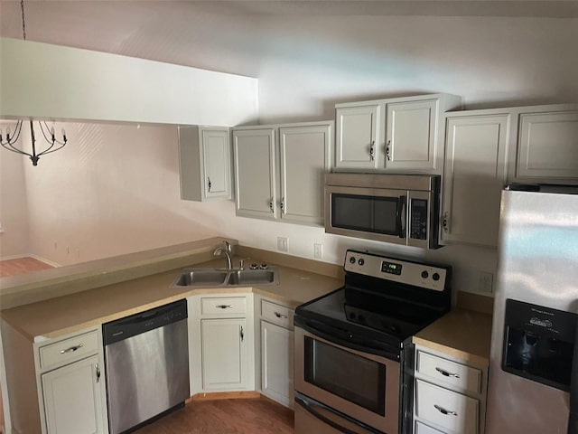 5417 Lake Margaret Dr Unit 39, Orlando, FL 32812 - kitchen featuring dark wood-style flooring, a sink, stainless steel appliances, light countertops, and white cabinetry