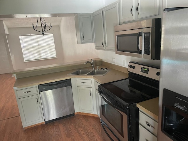 5417 Lake Margaret Dr Unit 39, Orlando, FL 32812 - kitchen with a sink, dark wood-style floors, a peninsula, appliances with stainless steel finishes, and light countertops