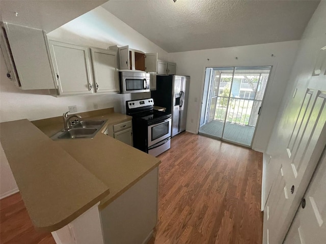 5417 Lake Margaret Dr Unit 39, Orlando, FL 32812 - kitchen featuring a sink, a textured ceiling, appliances with stainless steel finishes, light wood finished floors, and lofted ceiling