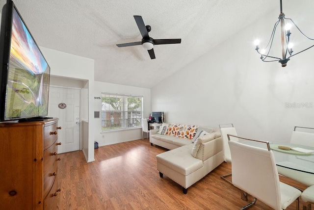 5417 Lake Margaret Dr Unit 39, Orlando, FL 32812 - living room with a textured ceiling, lofted ceiling, light wood-style floors, a ceiling fan, and a chandelier
