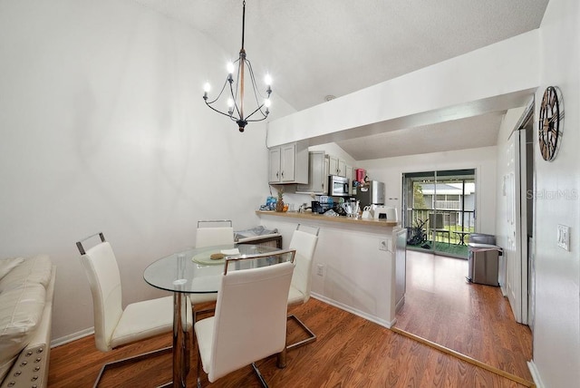 5417 Lake Margaret Dr Unit 39, Orlando, FL 32812 - dining space featuring vaulted ceiling, wood finished floors, and a chandelier