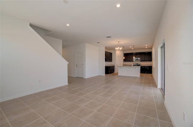 unfurnished living room featuring light tile patterned flooring, a notable chandelier, recessed lighting, and baseboards