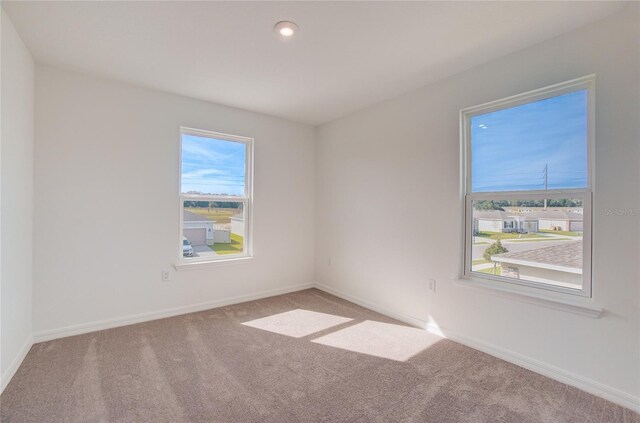 spare room featuring carpet flooring, recessed lighting, and baseboards