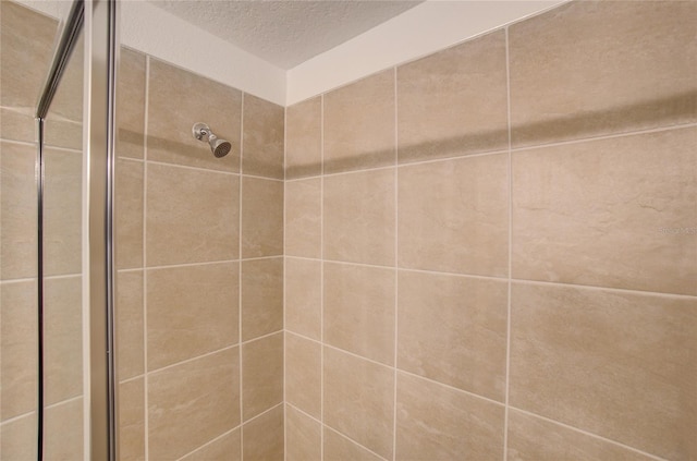 full bathroom with a stall shower and a textured ceiling