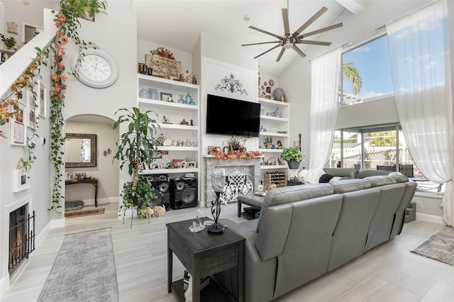 3244 Amaca Cir, Orlando, FL 32837 - living room featuring a fireplace with flush hearth, high vaulted ceiling, ceiling fan, arched walkways, and beamed ceiling