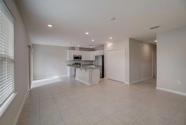 kitchen with visible vents, baseboards, open floor plan, stainless steel appliances, and white cabinetry