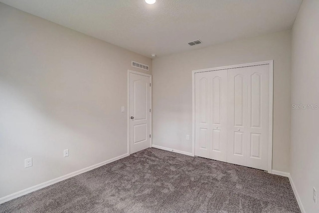 unfurnished bedroom with carpet flooring, baseboards, and visible vents
